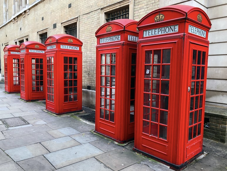 Several red British style telephone booths.